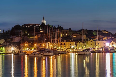 View of the town with sailing boats and lights reflecting in the water