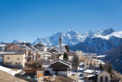 Mountain village Guarda in front of snowy mountains
