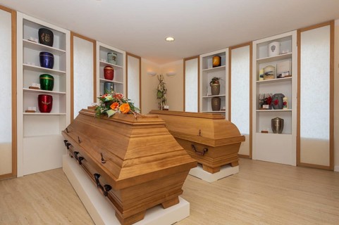 Coffins and urns in the exhibition room of a funeral parlour