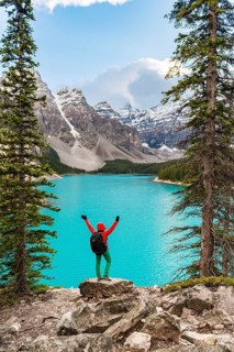 Hiker stands on the shore of a lake