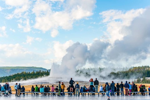 Tourists observe eruption of Old Faithful Geyser
