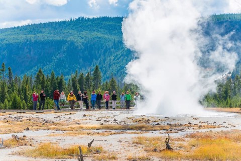 Tourists observe the eruption of the Geyser