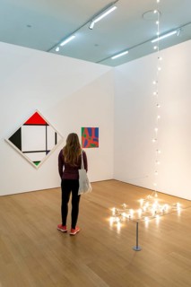 Visitor looks at modern paintings