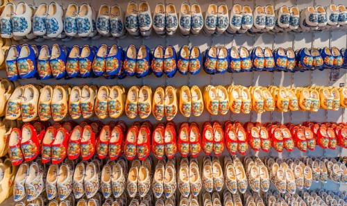Traditionally colorfully painted Dutch wooden shoes on rack for sale