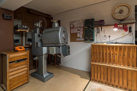 Cinema projectors by Zeiss Ikon around 1950 with film reel cabinets in a cinema projection room