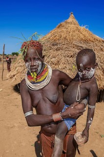 Woman with child of the tribe of the Karo with face painting and necklace