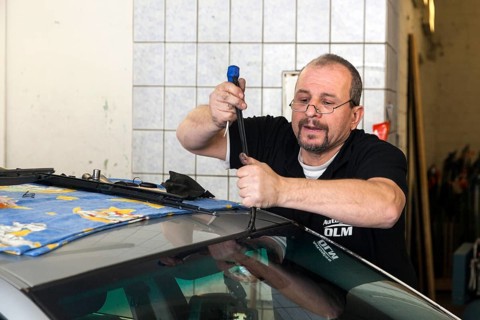 Changing the windscreen of a car in a garage for car glass