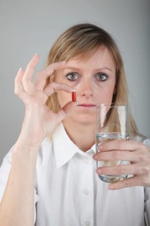 Young woman taking a capsule