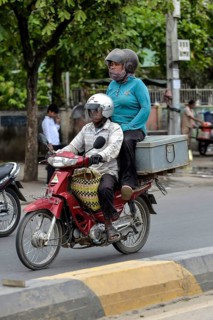 Man on moped and woman sitting on a box