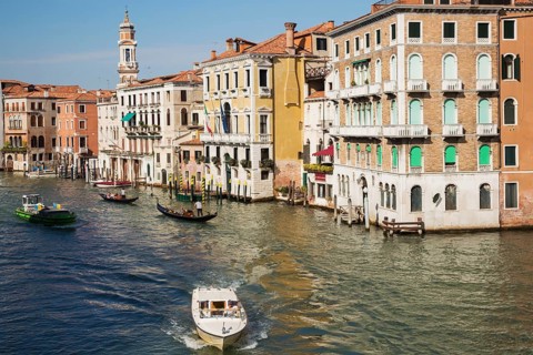 Water taxi and gondolas on Grand Canal lined with Renaissance architectural style residential palace buildings