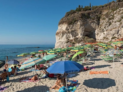 Many people with colorful sunshades at Lido Isola Bella Beach