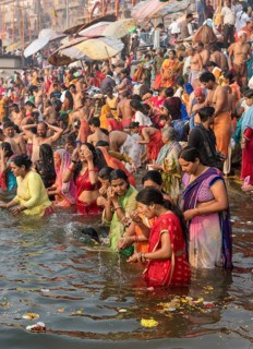 Hindu believers bath and perform ritual bath and puja prayers at ghats in the River Ganges
