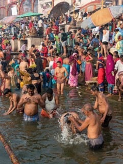 Hindu worshippers perform ritual bath and puja prayers at ghats in the River Ganges