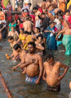 Hindu worshippers perform ritual bath and puja prayers at ghats in the River Ganges