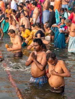 People perform ritual bath and puja prayers at ghats in the River Ganges