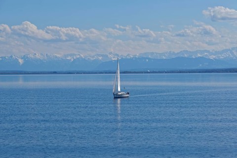 Lake Ammer with sailboat and the snow-covered Alpine peaks in the background