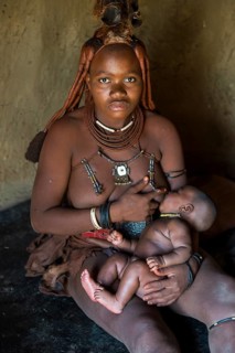 Himba woman breast feeding her baby