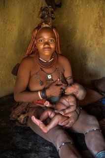 Himba woman breast feeding her baby