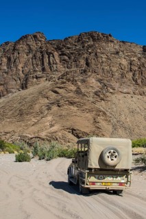 Tourist jeep driving through the deep sand searching for safari