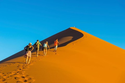 Tourist group walking up the giant sanddune Dune 45