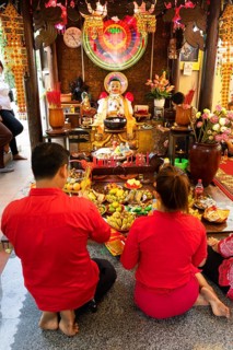Couple offering offerings in the courtyard of the temple Wat Phnom Daun Penh