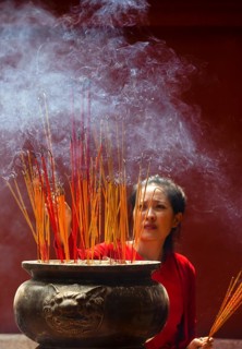 Young woman with burning incense sticks on Chinese New Year