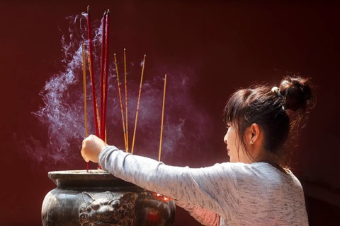Young woman with burning incense sticks on Chinese New Year