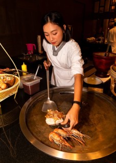 Thai cook preparing pad Thai and prawns