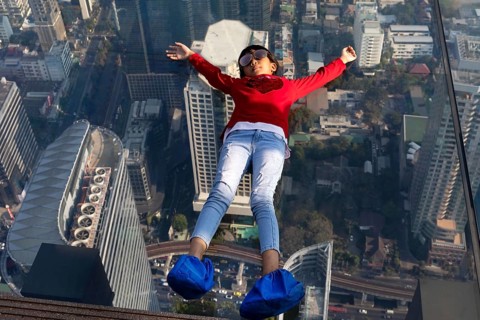 Little girl lies on the glass skywalk