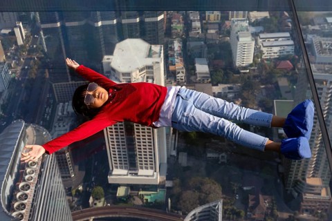 Little girl lies on the glass skywalk
