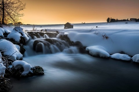 Bach in wintry landscape at sunset