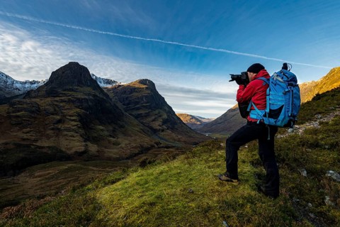 Photographer in mountain landscape with peaks of Stob Coire nan Lochan