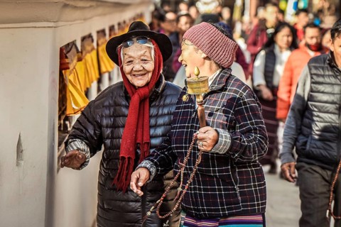 Laughing Tibetan women with prayer wheel