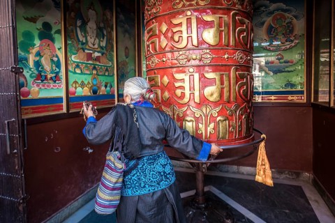 Buddhist turns to prayer wheel