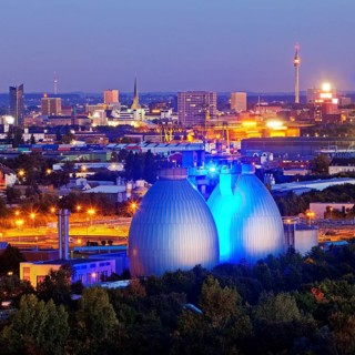 City viwe with the illuminated digesters of WWTP Dortmund Deusen II