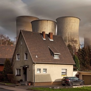Residence in the Auenheim district in front of the steaming lignite-fired power plant Niederaussem