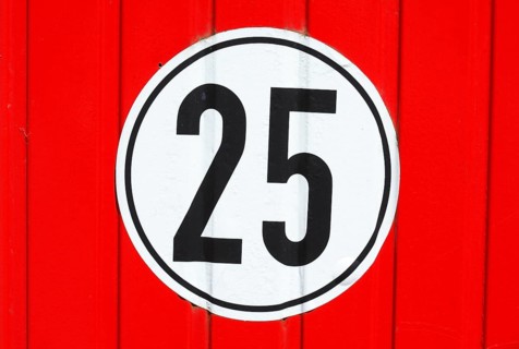 Road sign speed limit 25 Km/h on red wood wall