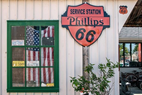 Window with American flag at historic gas station Shea's Gas Station