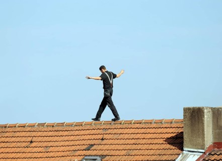 Chimney sweep balances on the roof