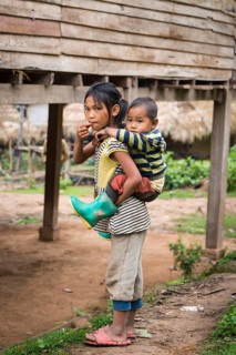 Girl carrying a young boy on her back