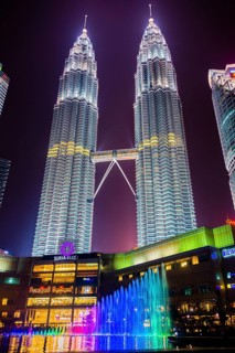 Lighted Petronas Towers with multicolored fountain at night