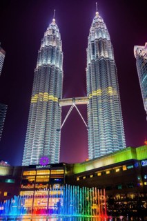 Lighted Petronas Towers with colored fountain at night