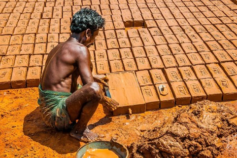 Indian man making clay bricks