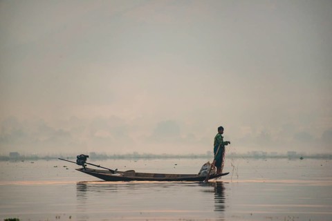 Local fisherman leg rower with wooden boat