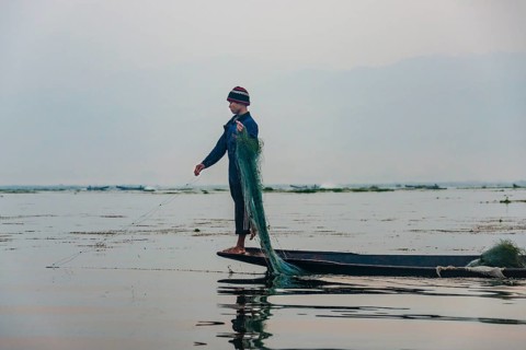Local fisherman leg rower with wooden boat