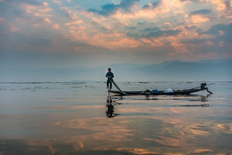 Local Intha fisherman rowing boat with one leg