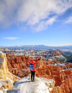 Young woman with outstretched arms overlooking the amphitheatre