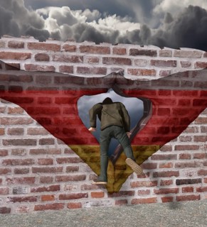 Man climbs through Merkel diamond on a wall with German flag