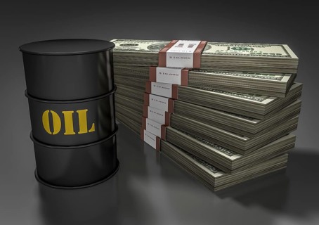 Oil barrel in front of stack of dollar bills