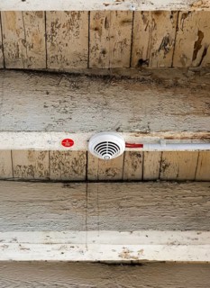 Smoke detector with electrical wiring on old wooden beam